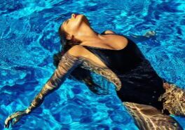 Portrait of young hot woman posing near swimming pool