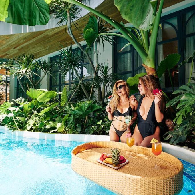 Female Friends Sitting at Swimming Pool